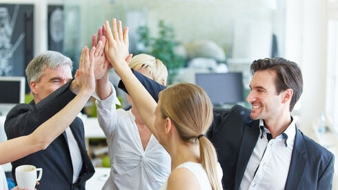 Business Team macht High Five im Büro